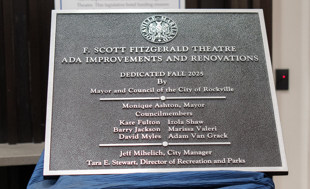 A metal plaque commemorates the ADA improvements and renovations at F. Scott Fitzgerald Theatre, dedicated in Fall 2023 by the City of Rockville officials and council members.