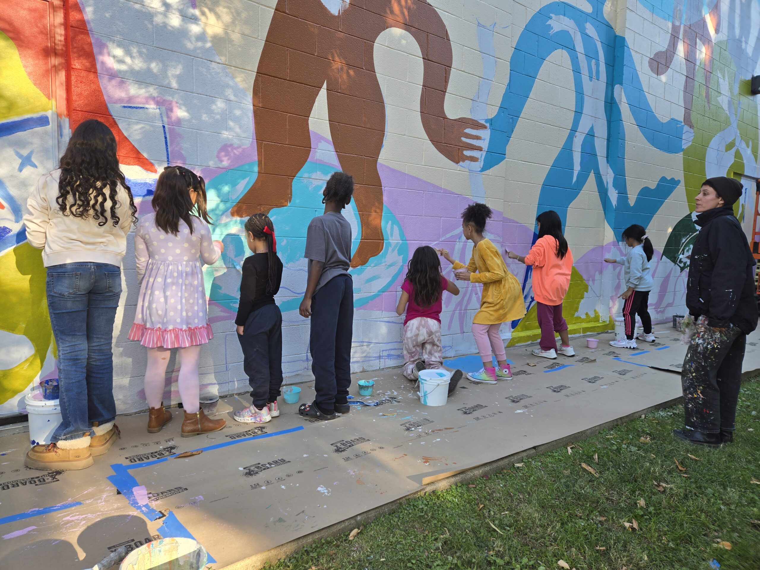 Artist Rose Jaffe helping kids paint a mural at Lincoln Park Community Center