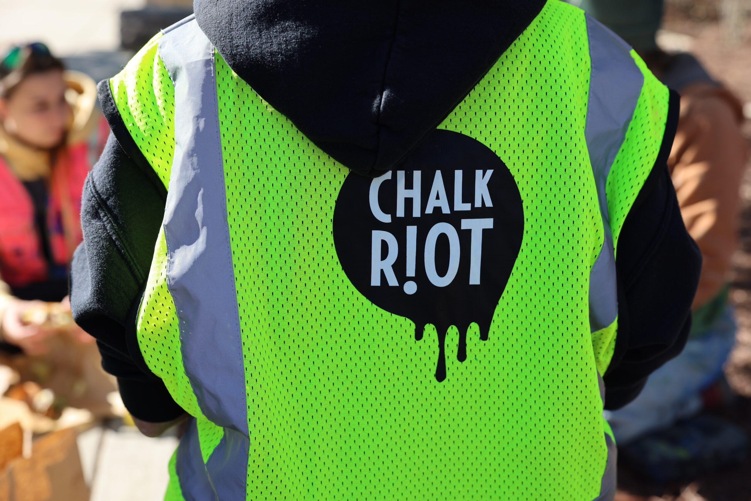 Back of a person wearing a Chalk Riot vest