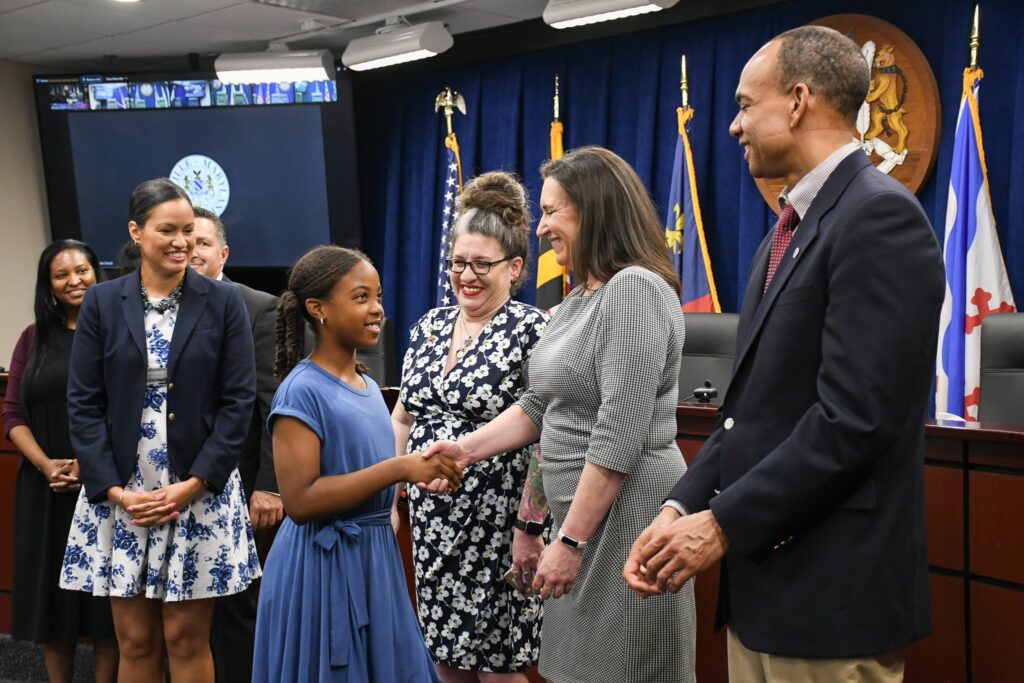 Callie Walker shaking hands with the Rockville Mayor and Council