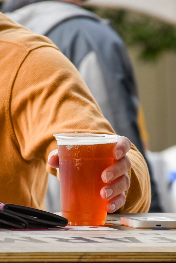 A man holding a cop of alcohol