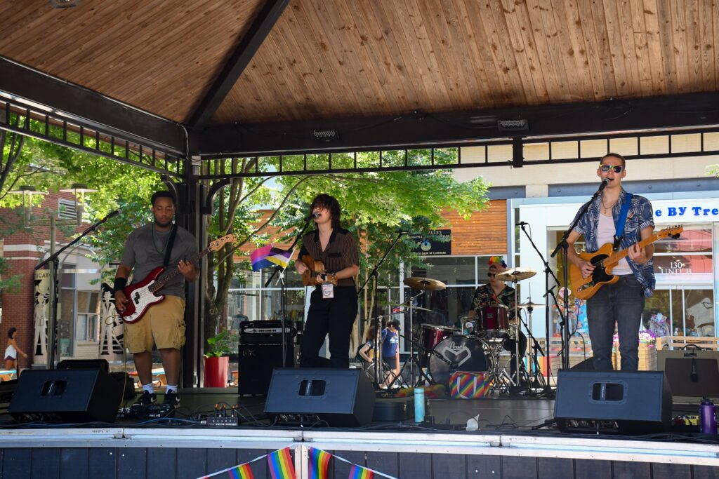 A band playing on stage outside at Rockville Pride