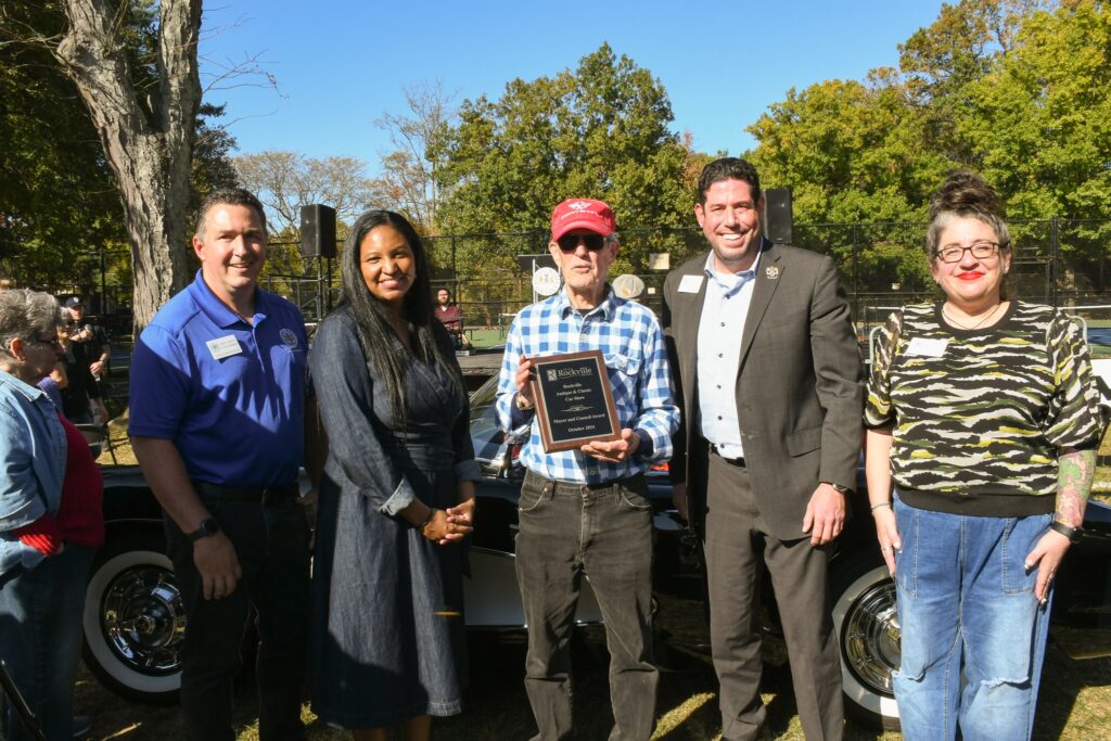 Cal Milans standing with his 1957 Chevrolet Corvette and Rockville Councilmembers at the Rockville Antique and Classic Car Show