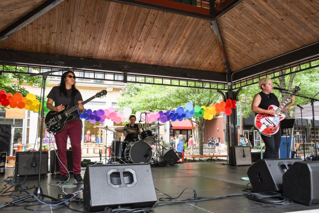 Band performing on outdoor stage at Pride Celebration