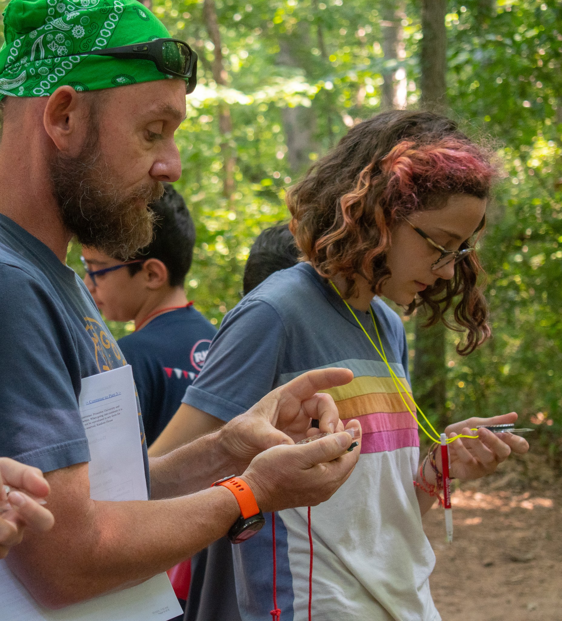 Kid learning to use a compass at camp