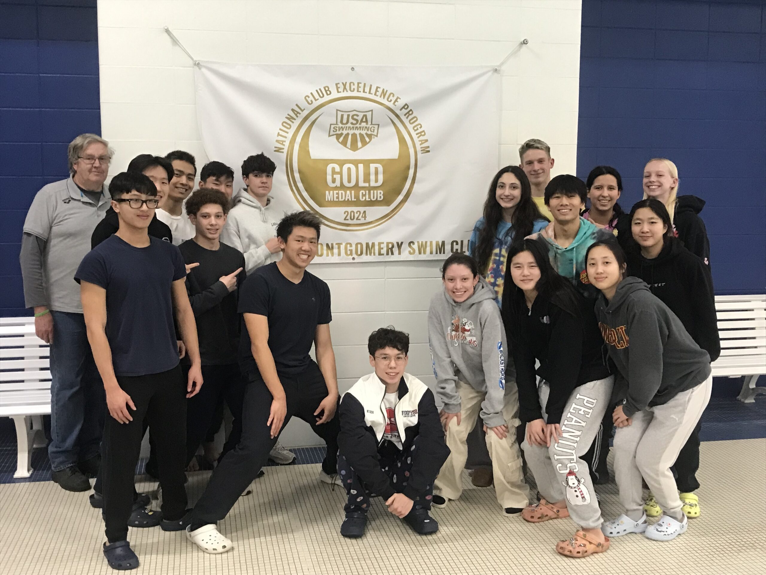 Rockville-Montgomery Swim Club posing in front of a Gold Medal Club sign