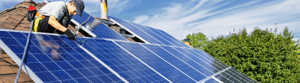Man on a roof installing solar panels