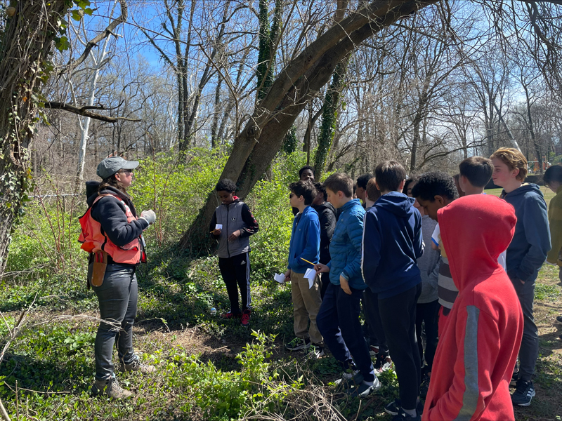 Natasha Shangold speaking with students in a forest