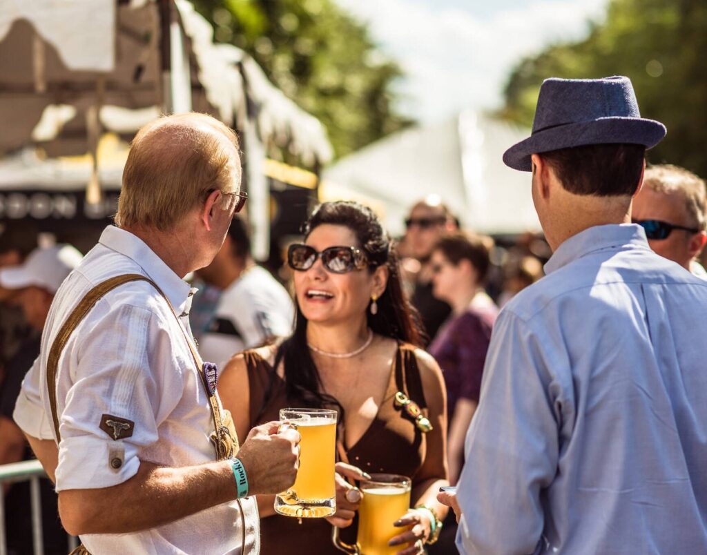 People sitting at benches talking and drinking beer