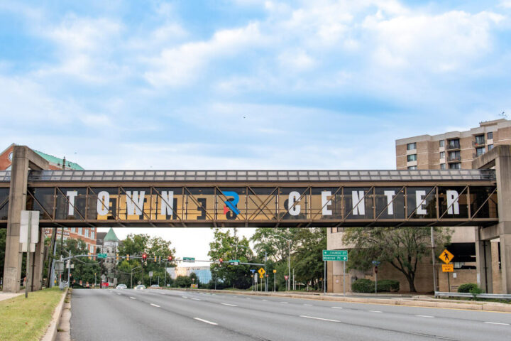 A pedestrian bridge spans a wide roadway, displaying the words 
