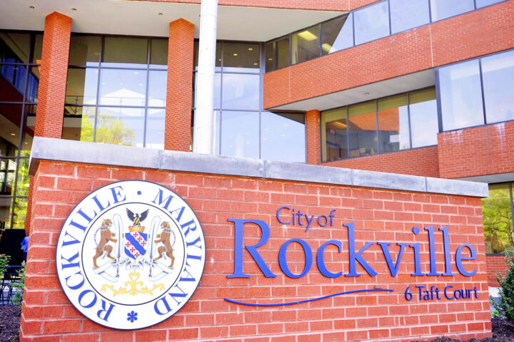 Exterior view of the City of Rockville, Maryland municipal building with a large sign displaying the city name and emblem in front.