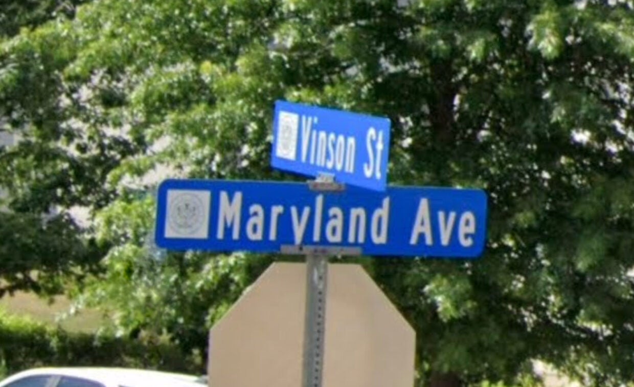 Street signs at an intersection showing Vinson St and Maryland Ave, with green trees visible in the background.