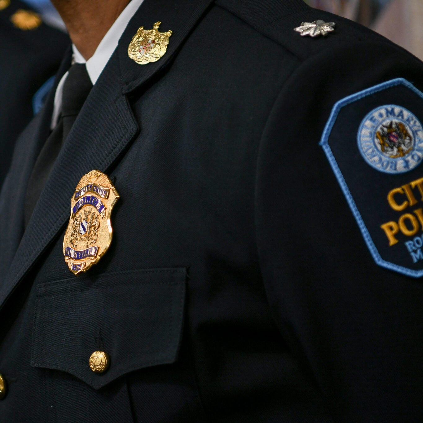 Several uniformed police officers stand in a row, with visible gold badges and department patches on their jackets.