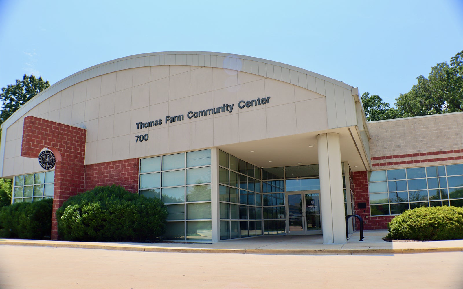 The front entrance of Thomas Farm Community Center with glass doors, red and beige walls, and the address number 700 displayed.